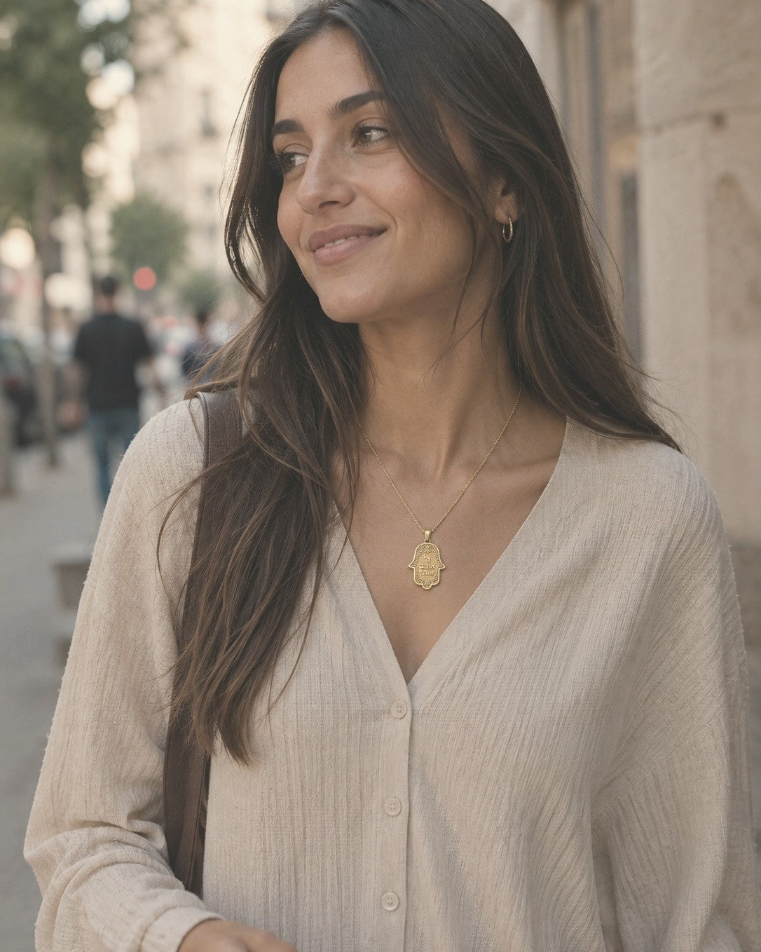 The Hamsa Pendant in gold worn on a city street — Hashem Loves Me jewelry